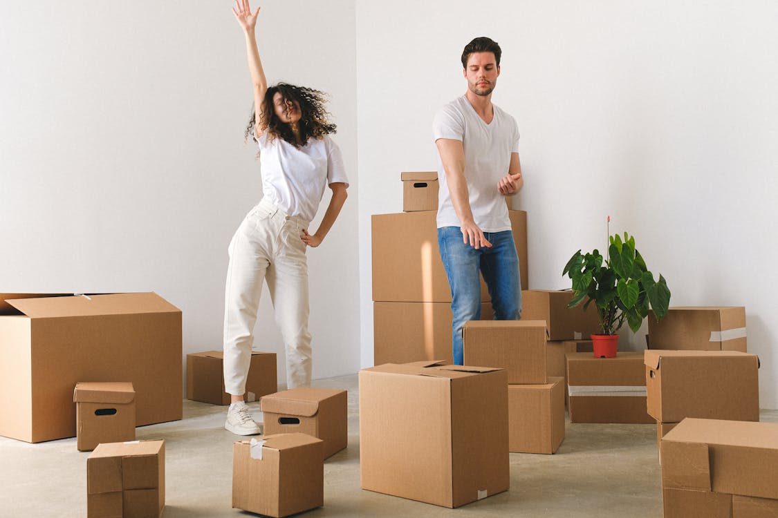Free Joyful young couple dancing after moving in new purchased apartment