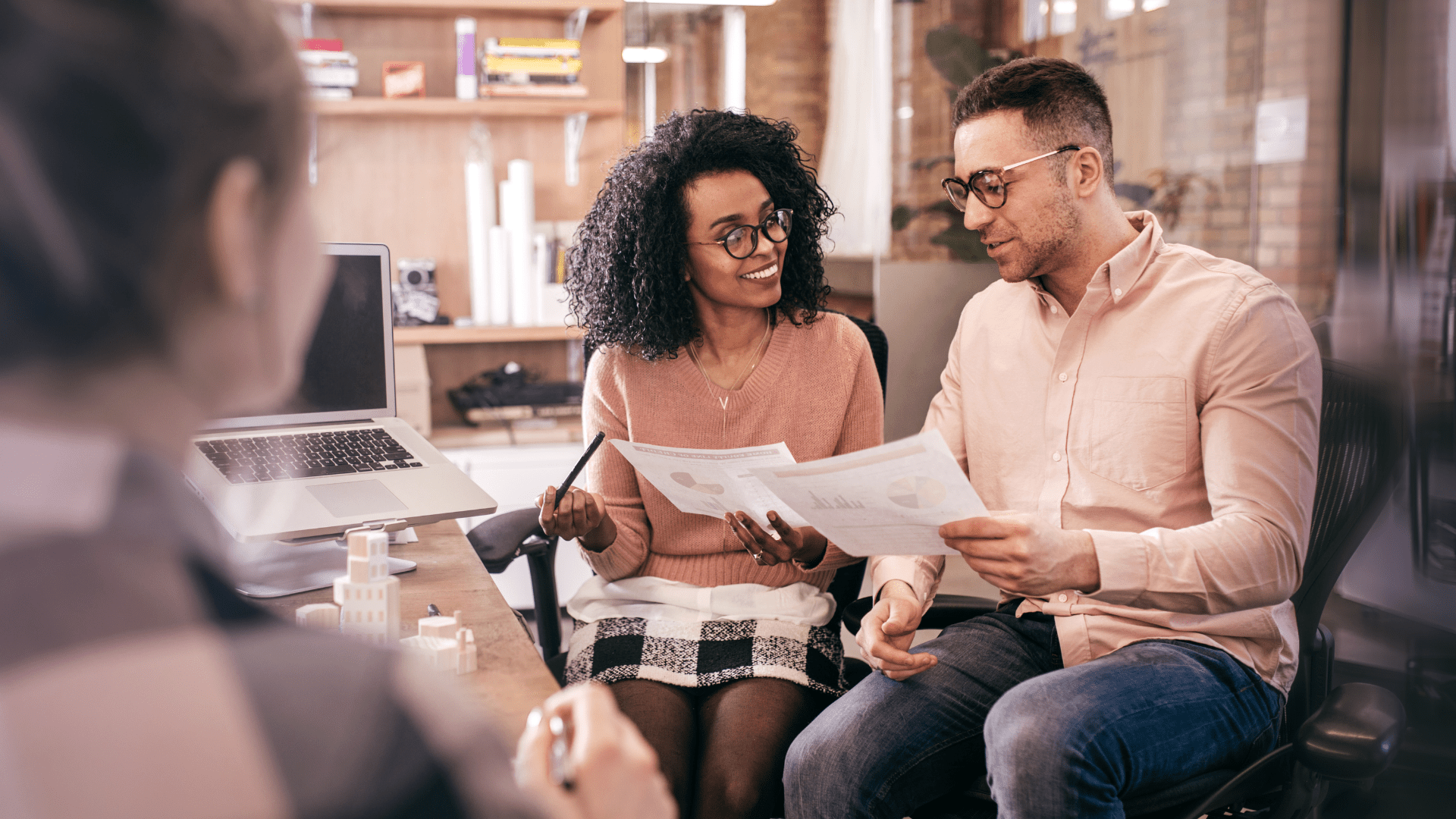 man and woman looking at documents in an office with an agent