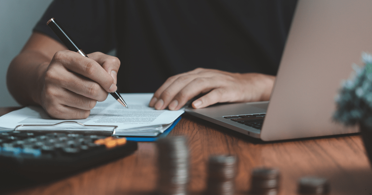 mortgage refinance rates - man using laptop, calculator and a pen for calculation