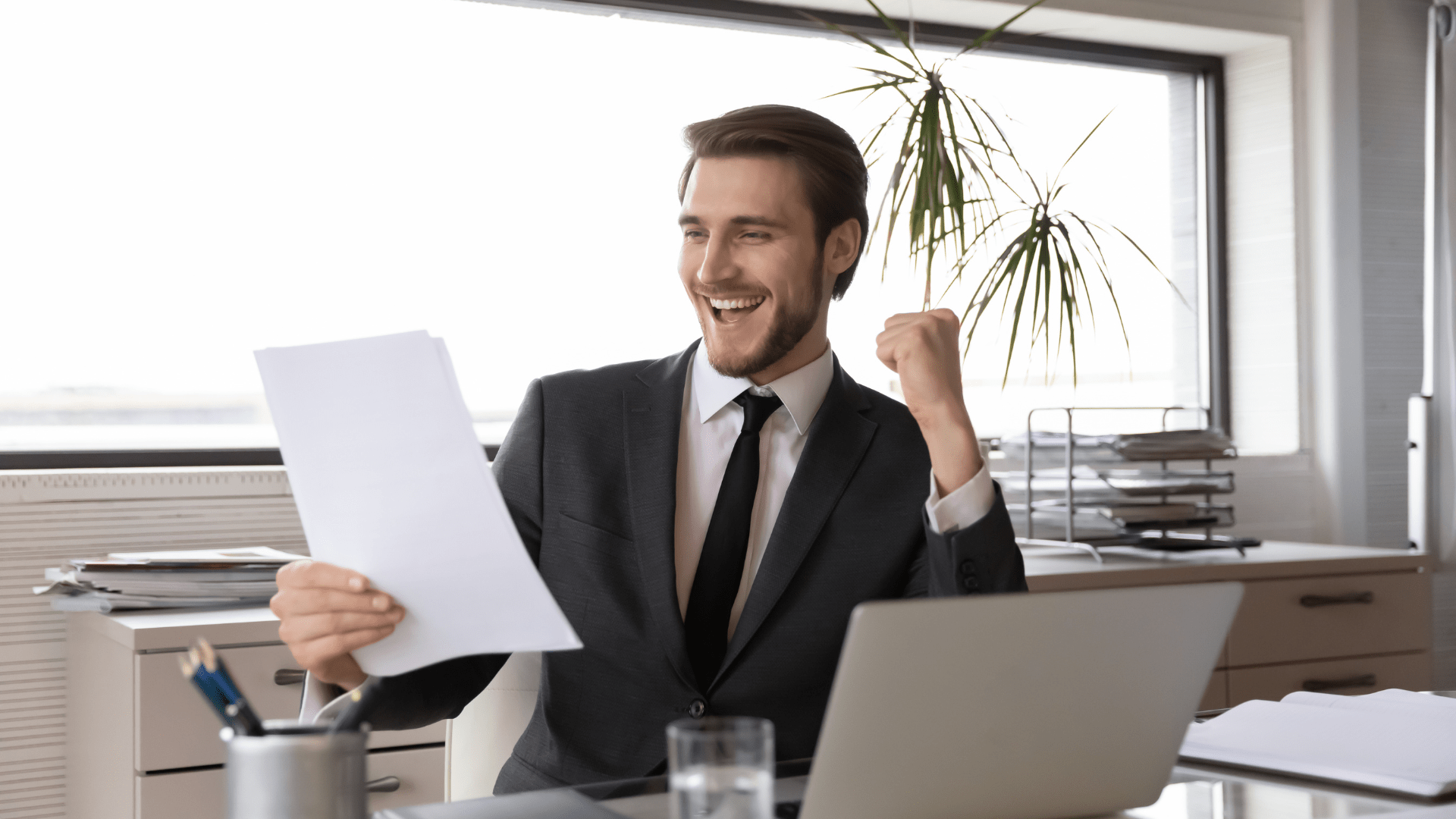 Happy man in a suit looking at a document