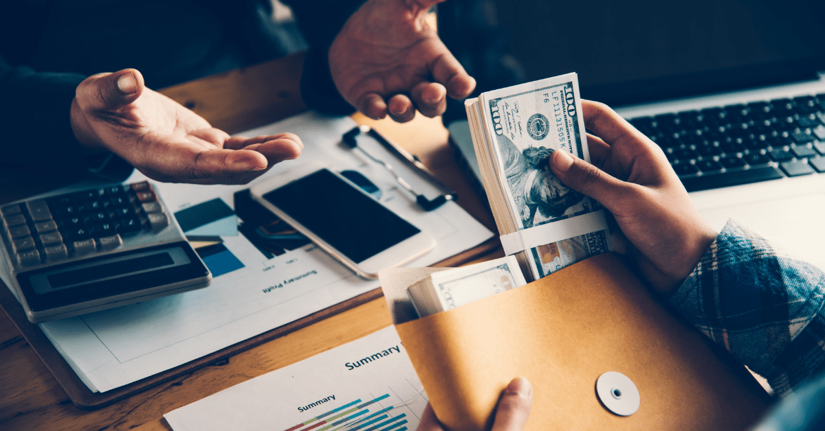 Property investment Loan options - a man is giving loan as cash to another man