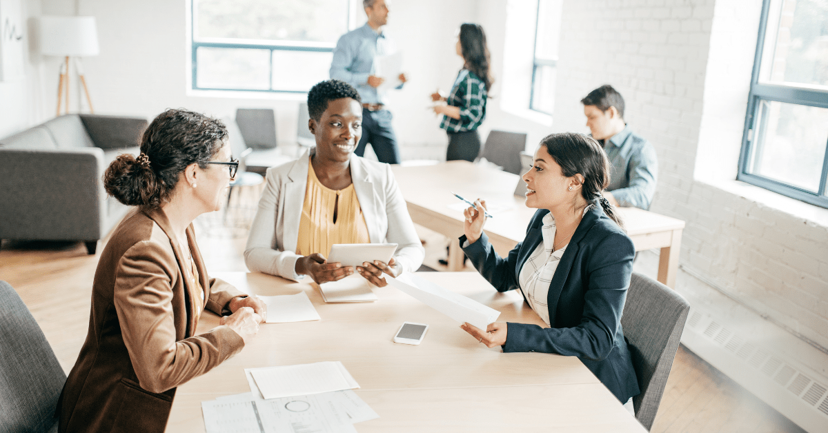 building wealth through investment property - image of three women talking with each other on a table