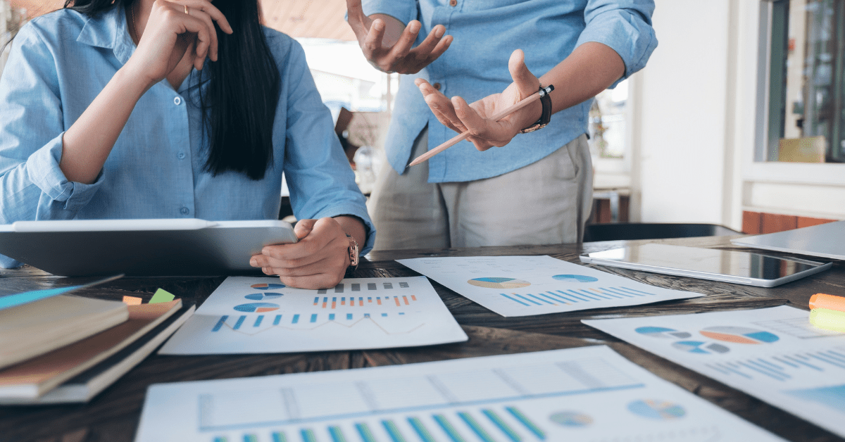 investing in property - image of two persons making a plan holding a tab there are some paper works for the planning