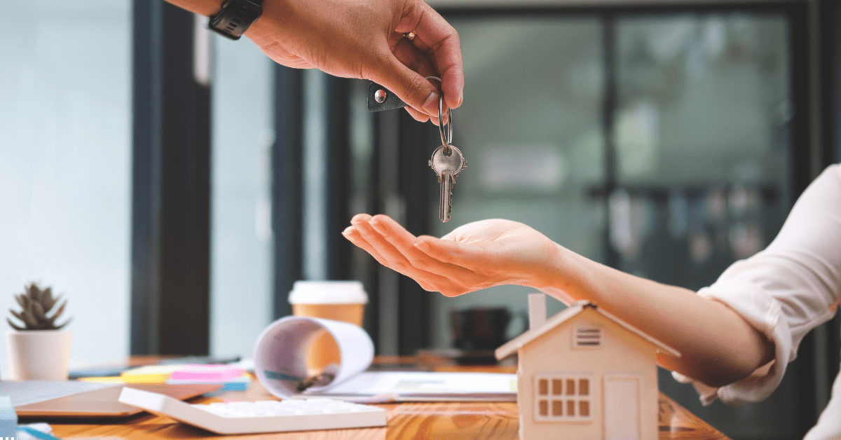 self-managed super fund Property Investment Image 01 - 1 person is giving property keys to property investor and there's a dummy home made with card board placed on a table