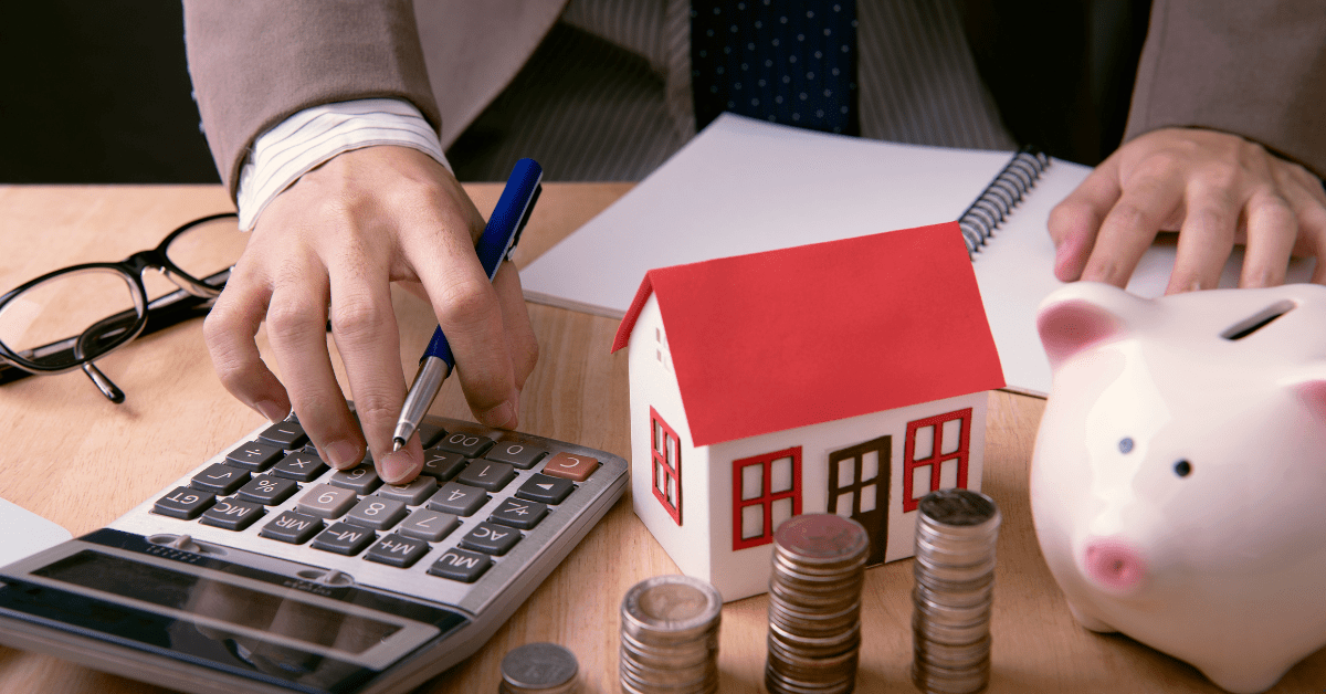 a person is calculating property investment journey using a calculator on his table
