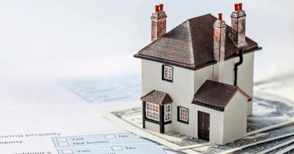 a dummy house on a piece of porpertyprice paper