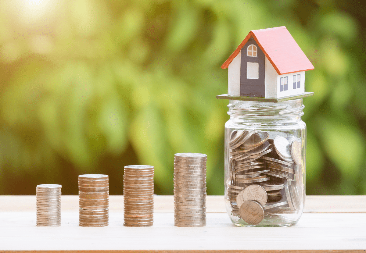 a jar full of coins and a dummy house over the jar