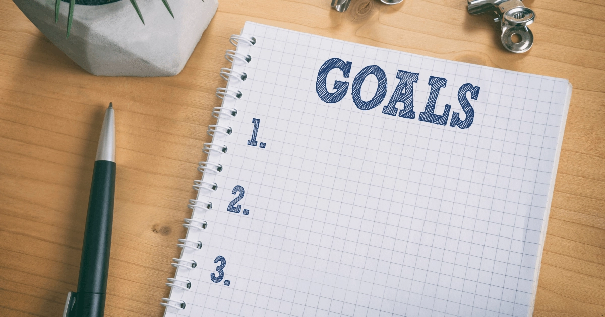Writing investment goals on a paper for achieving financial freedom using property investment