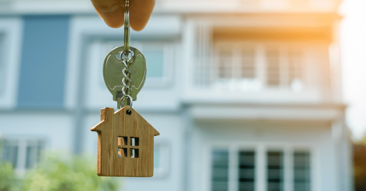 Rental Yield - Person Showing A Key Infront of a Property