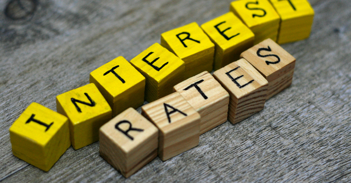 Block letters spelling "Interest Rates" in yellow and wooden cubes, relevant to discussions on borrowing capacity and property investment in the context of rising interest rates.
