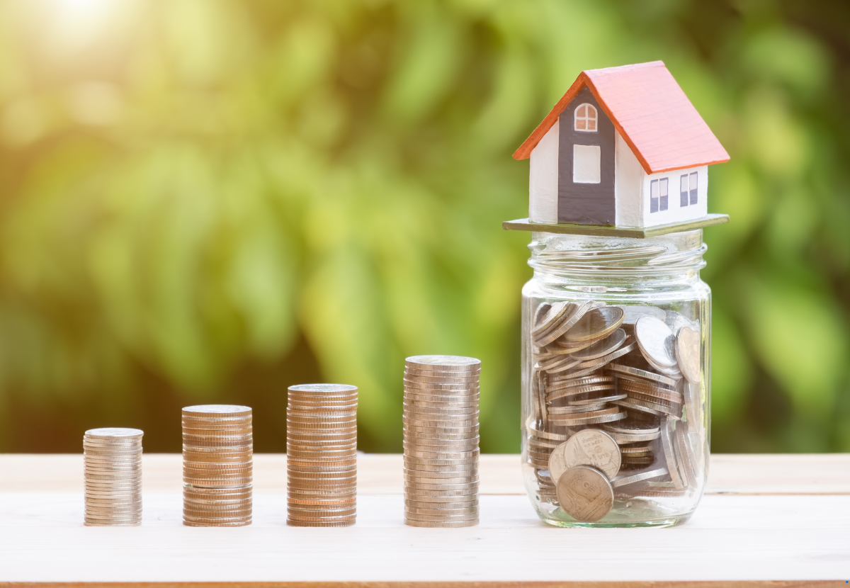a jar full of coins and a dummy house over the jar
